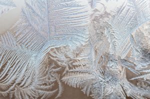 Ice floral pattern on glass in blurred vignette macro view